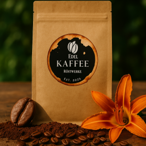 Ein brauner Kaffeebeutel aus Kraftpapier von Edel Kaffee Röstwerke steht aufrecht auf einer rustikalen Holzoberfläche. Das runde Logo mit zwei Kaffeebohnen über dem Schriftzug ‚Edel‘, darunter ‚KAFFEE‘, ‚Röstwerke‘ und ‚Est. 2025‘, ist mittig auf dem Beutel platziert. Umgeben ist der Beutel von Kaffeebohnen, Kaffeepulver, einer großen gerösteten Bohne und einer orangefarbenen Blume – symbolisch für die belebenden, floralen und kräftigen Noten des Sidamo Bio Espresso. Im Hintergrund: grüne Natur, warmes, lebendiges Licht.